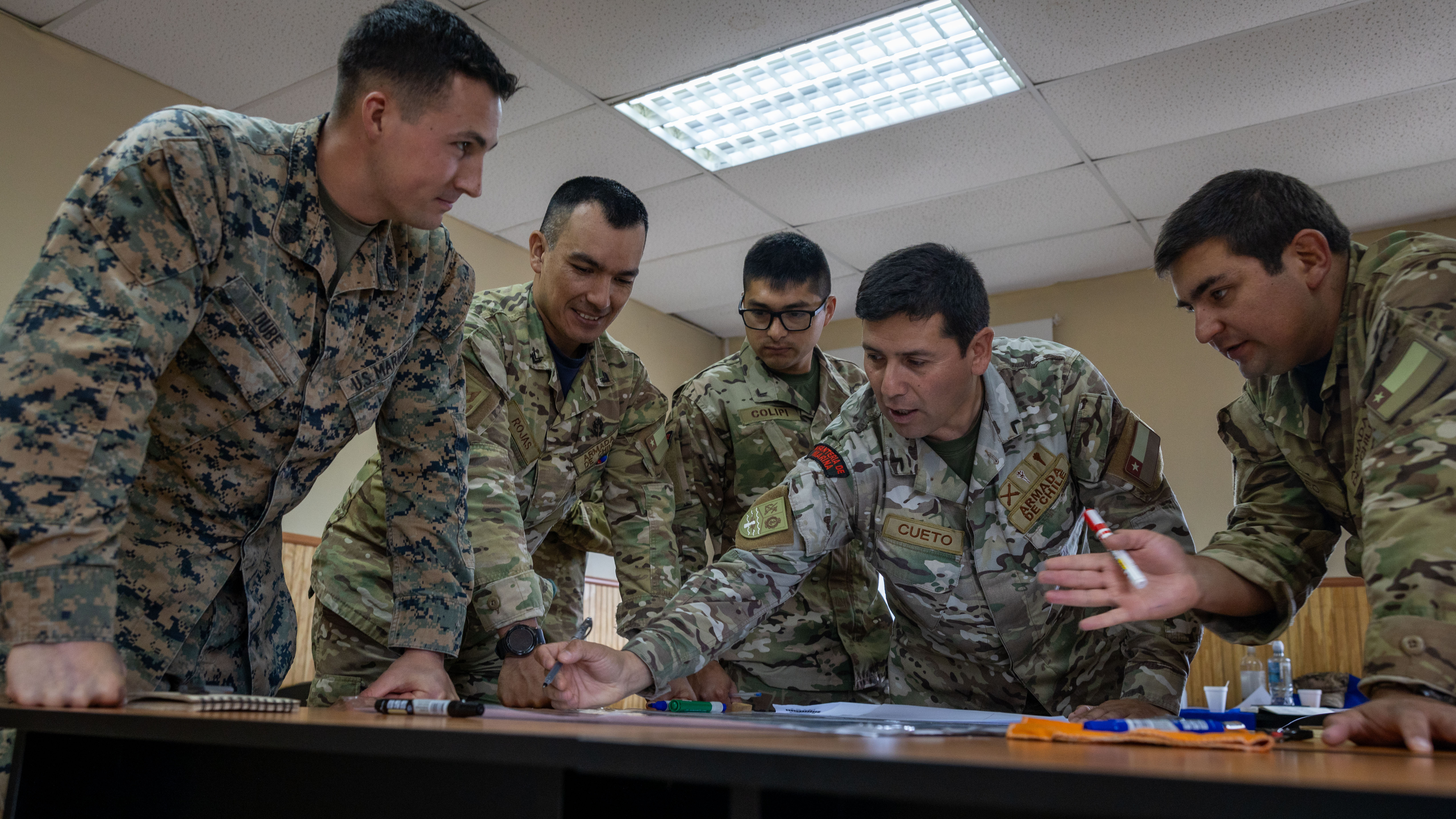 Marine Corps Sergeant Matt Dube, 1st Battalion chief scout, 25th Marine Regiment, 4th Marine Division, Marine Forces Reserve, and Chileanmarines from Cuerpo de Infantería de Marina Chile Brigade, Armada de Chile, plan wargame strategy during Amphibious Intelligence SubjectMatter Expert Exchange in Fuerte Aguayo, Chile, March 27, 2024 (U.S. Marine Corps/David Intriago)